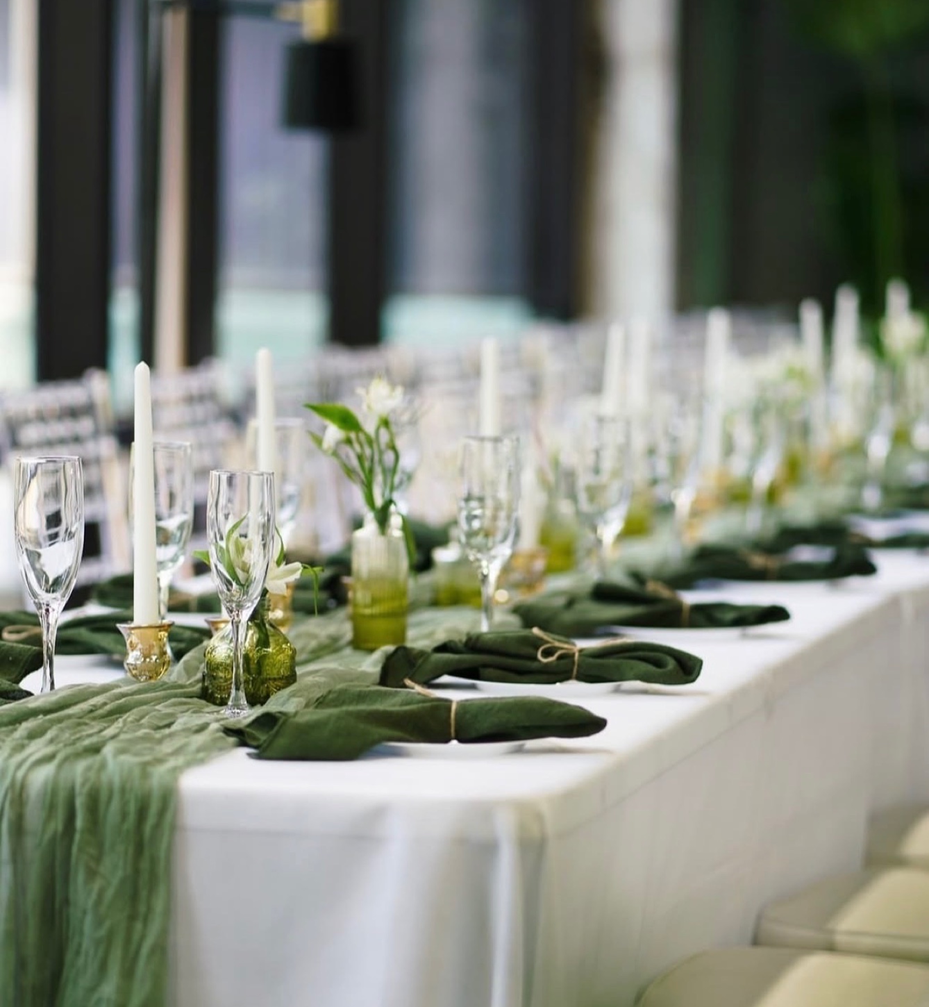 Long table with sage runners, forest green napkins and white taper candles