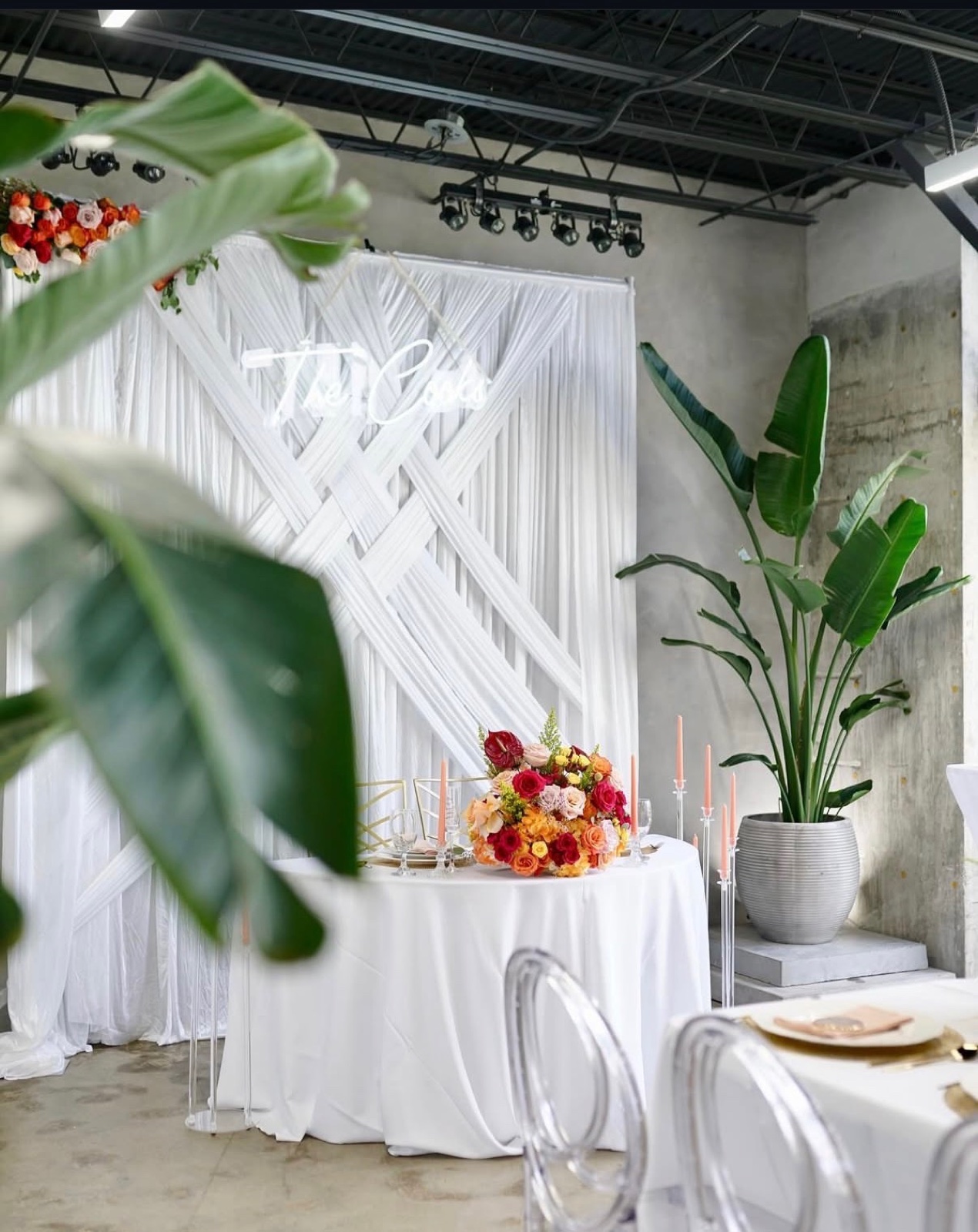 Sweetheart table in front of a woven white drape backdrop