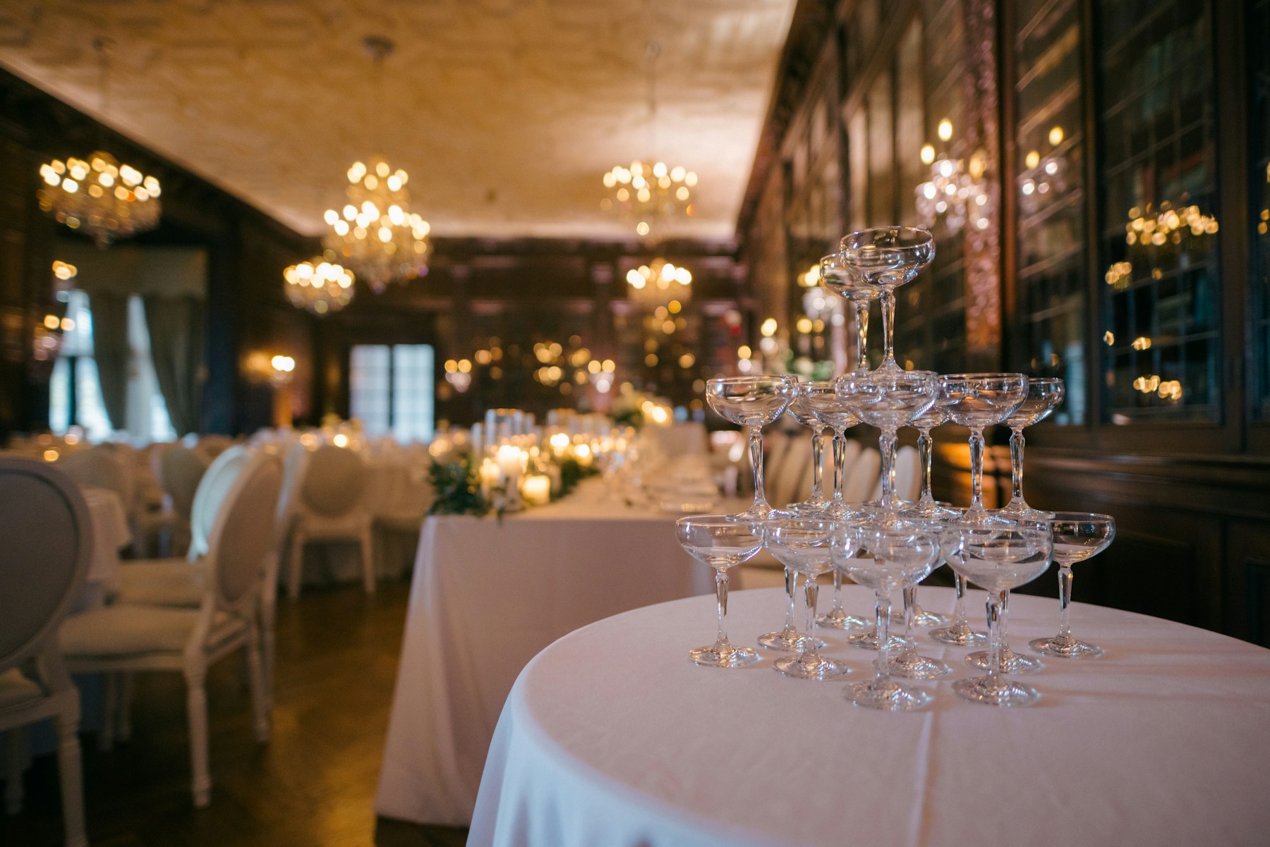 Champagne tower on an ivory table under chandeliers
